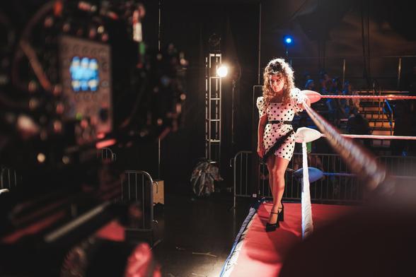 Paula Abdul stands ringside on mid-right of frame, in costume as Mary Todd in the feature film, Raging Midlife. Left side of frame has a Sony Venice Cinema camera in the foreground