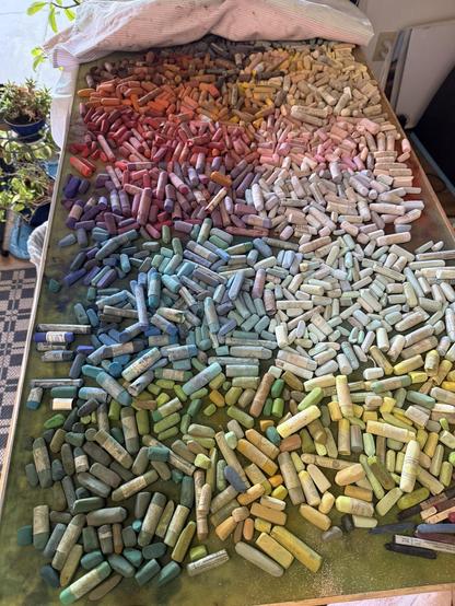 A huge tray (4 ft x 2 ft) full of pastel sticks. Roughly arranged in hues and values.
