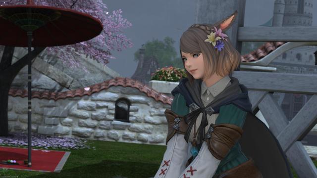 Young miqo'te woman with short brown hair and pastel flowers in it. She's wearing a green dress with white undershirt and white armguards with brown leather accents and red stitching. She's sitting in a gazebo as it rains in the background behind her.