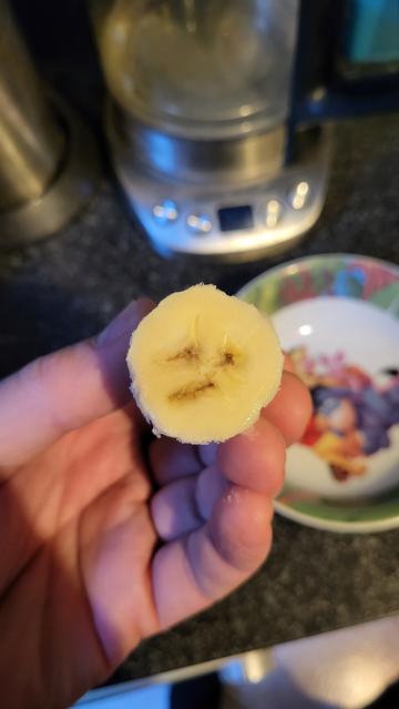 Ich halte eine abgeschnittene Banane in der Hand. Der Querschnitt sieht aus, wie der "diagonal mouth" Smiley.