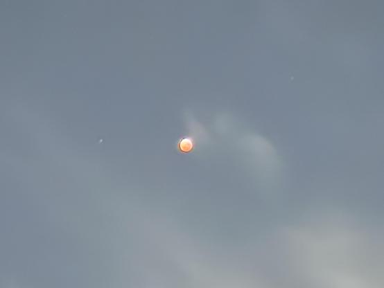 A total lunar eclipse in a hazy night sky.