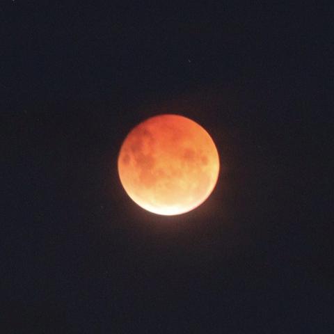 The moon is dark red at the top all the way down to light white at the bottom left