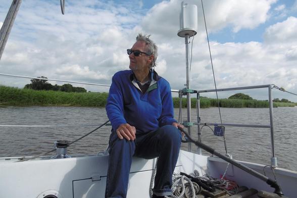 Ein Mann steuert sein Segelboot