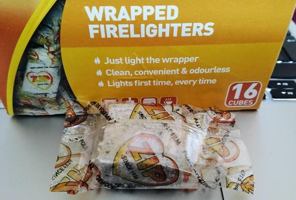A box of individually wrapped "ZIP" firelighters, claiming to be odourless, and cubes. One is taken out of the box. One dimension of the firelighter is less than half the other two, and I'm obsessed by facts.