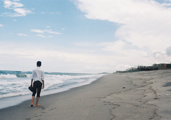 Adrian walking away from the camera at the beach.