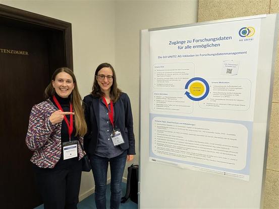 Two women presenting the Go Unite Poster