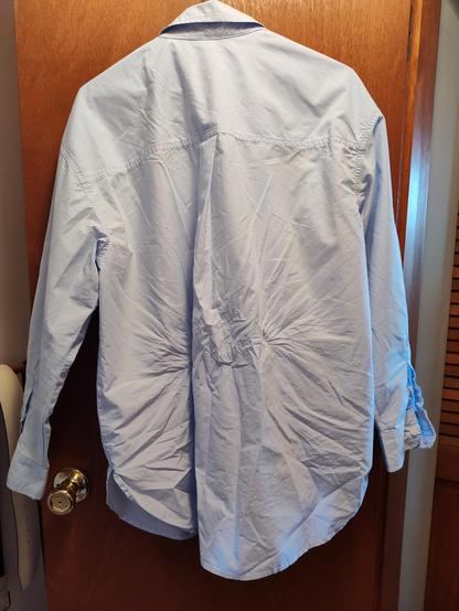 Back of a pale blue cotton button down shirt with major wrinkles just from trying it on.