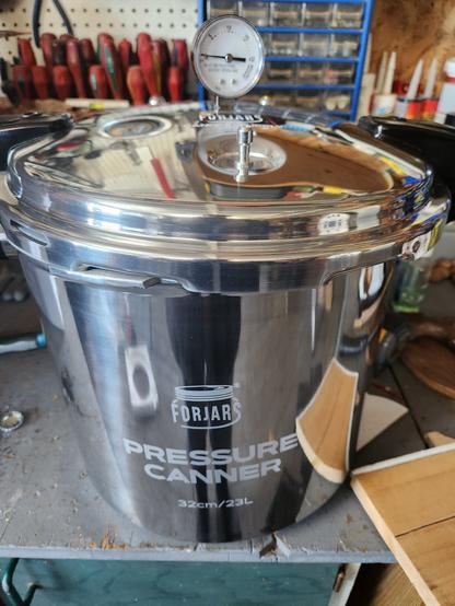 Large silver pressure canner with dial gauge on top