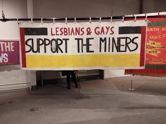 The original handmade banner reading "Lesbians and Gays Support the Miners" on display in the People's History Museum, Manchester.