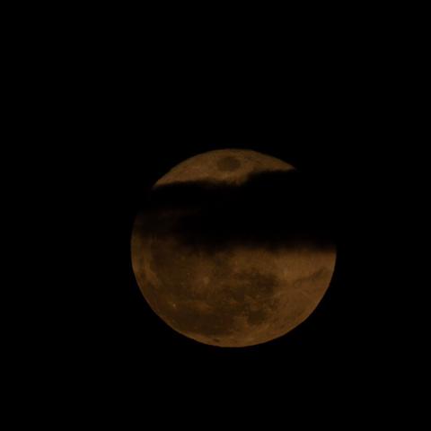 luna llena parcialmente cubierta por nubes