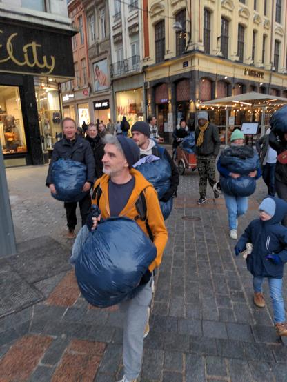 Les activistes arrivent sur la place avec de gros SACD poubelle emplis de vêtements