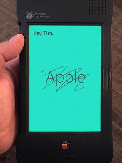 Photo of an Apple Newton MessagePad 2100 with the phrase "Hey Tim," followed by the word "Apple" with a scribble obscuring it
