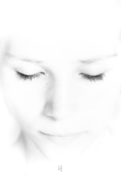 a high key close up portrait shot of a woman with her eyes closed.
