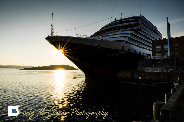 Sunrise starburst from behind the bow of a cruise ship.
