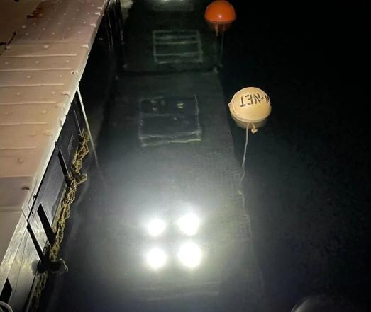 image/jpeg frames are deployed in shallow water by a dock, one with an array of four bright lights. Photo from Ohio State University.
