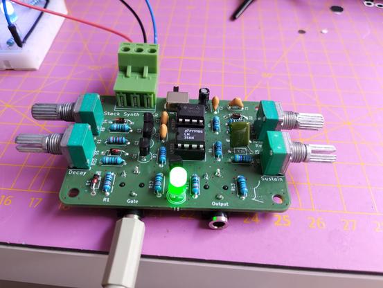 the finished ADSR board. it is powered and has a cable in the gate. the LED is lit, indicating the output being active.