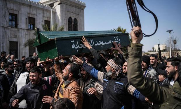 Combatientes y civiles sirios portan el 9 de marzo de 2025 el ataúd de un miembro de las fuerzas de seguridad sirias durante su funeral en la provincia de Hama, tras ser emboscado en Latakia. (Moawia Atrash / picture alliance via Getty Images)
