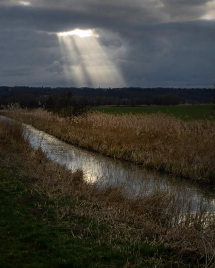 A scene from the polder near Ooij, Netherlands. The dark clouds are opening up to let through a beam of light.