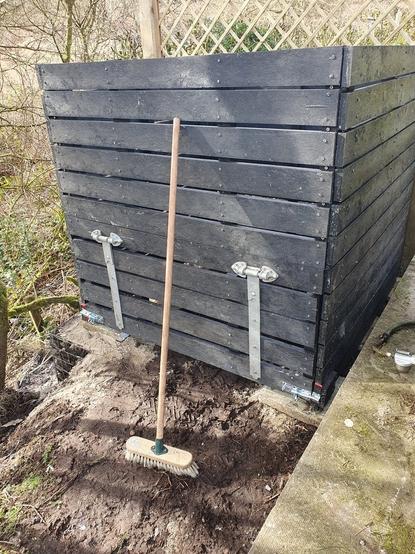 Bin compost mawr wedi ei adeiladu efo planciau o blastig du wedi'i ailgylchu.  Mae hi'n posib i agor rhan gwaelod y blaen i dynnu compost allan.
