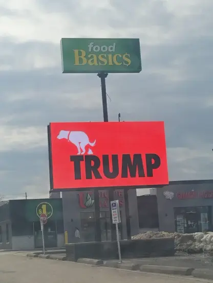 Digital sign, displaying line drawing of a dog defecating on the name Trump