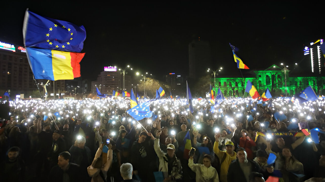 The moment when protesters formed a heart using their phones to light up white sheets with blue writing. In the background, ❝Ode to Joy,❞ the European anthem, is heard.   ❝Romania, awaken!❞ is chanted in the square