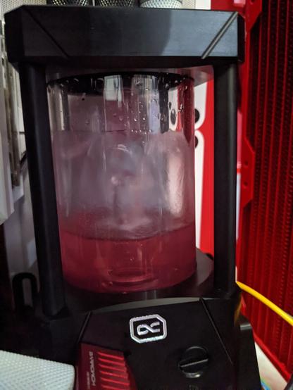 Photo of a black and glass fluid reservoir filled with red fluid