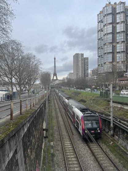 RER C qui passe sous un pont, on voit la tour eiffel derrière