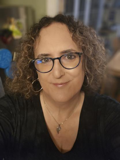 Melissa in her kitchen. She is plainly visible, and Visibly trans