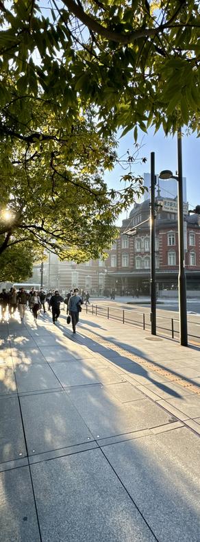 Vertical panorama photo of the morning sun flooding the Marunouchi area outside Tokyo Station in Tokyo, Japan.