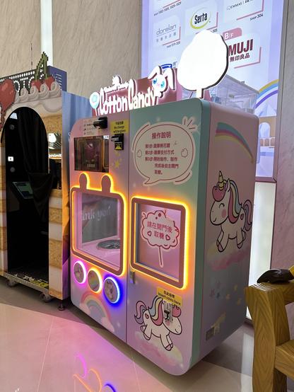 Ein Automat der Zuckerwatte macht und verkauft. Darauf ist ein Einhorn gemalt.