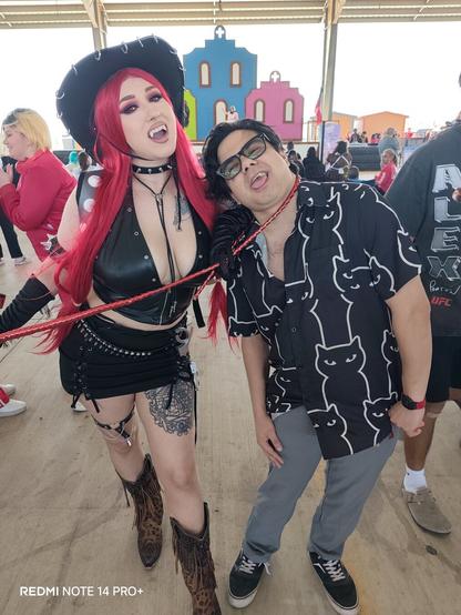 A close-up, forward shot of a Bowsette cowgirl cosplay and a person in a black cat shirt, a 'REDMI NOTE 14 PRO+', visible in the lower left corner.