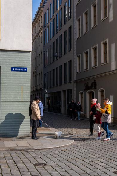 Ein Mann mit Hund an einer Straßenecke.