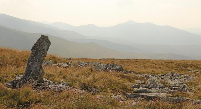 a single upright finger of rock in the middle of nowhere on a remote Welsh mountain, beyond, even more mountains fade into the hazy distance.