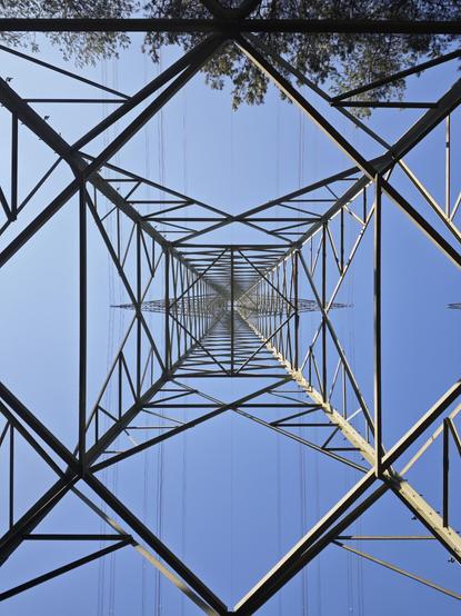 View straight up from below an electrical tower.