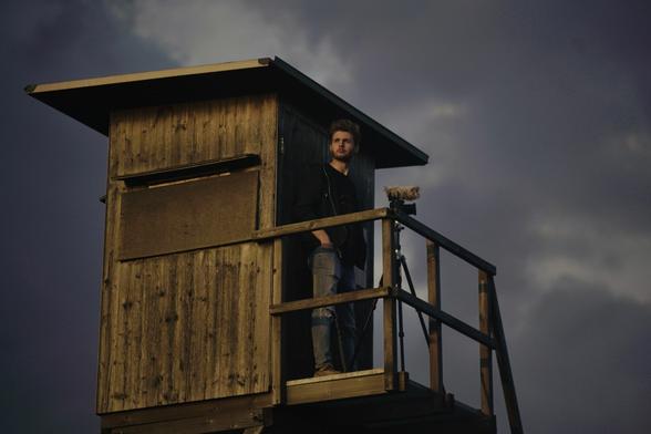 Foto von Maxi Buck mit Kamera auf einem Hochsitz