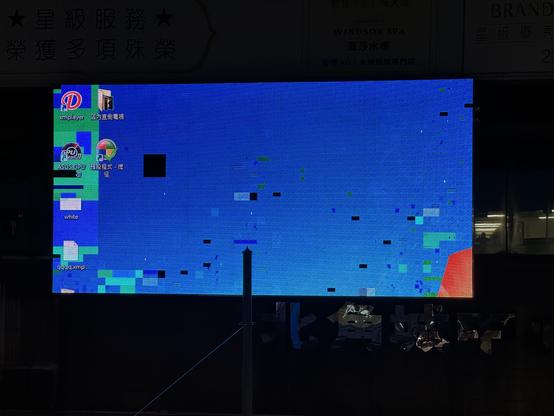 Die LED Wand von nahen. Einige Panelteile sind ausgefallen, andere farblich stark verzerrt. Zu sehen ist ein Windows Desktop mit ein paar icons.