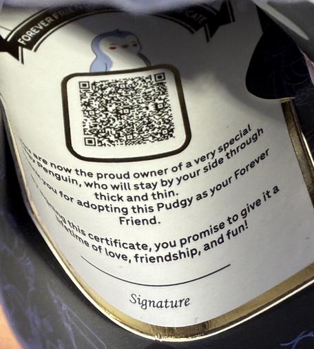 Ein QR Code auf Pappe und ein Text, dass man jetzt stolze Eigentümerin dieses Tiers ist.