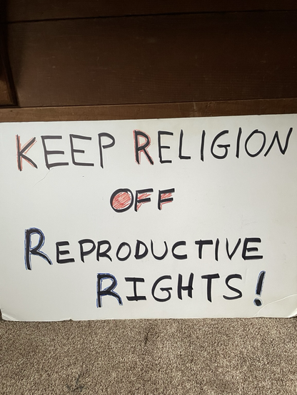 A handmade protest sign that says keep religion off reproductive rights