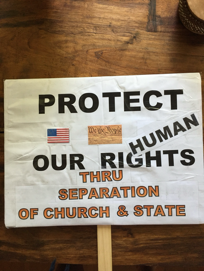 Handmade protest sign that says protect our human rights through separation of church and state