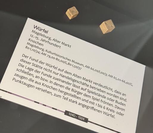 2 Knochenwürfel und Ausstellungstext