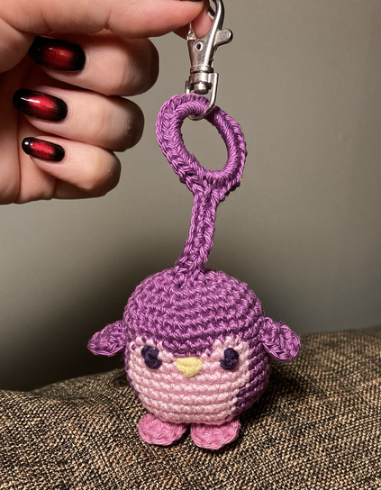 Purple and pink crocheted penguin attached to a key ring fob
