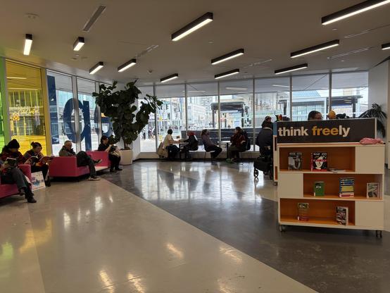 Inside the Milner EPL with people with pride flags reading and an EPL sign saying think freely.