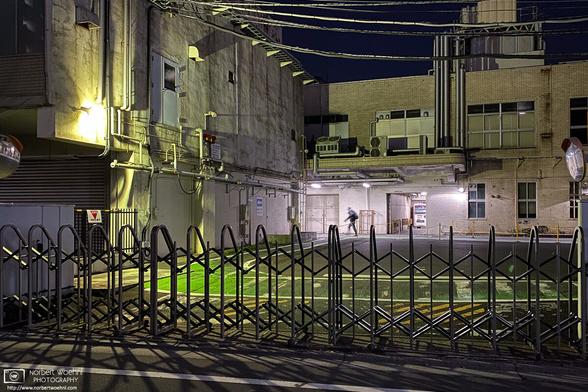 A night shift worker walks inside the premises of an industrial complex in the Shimura area of Itabashi Ward, Tokyo.