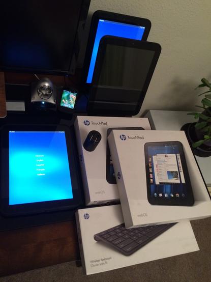 My webOS device pile back when I did webOS development. There are three palm Touchpad tablets, a palm Veer on a Touchstone charger, and an HP webOS bluetooth keyboard.