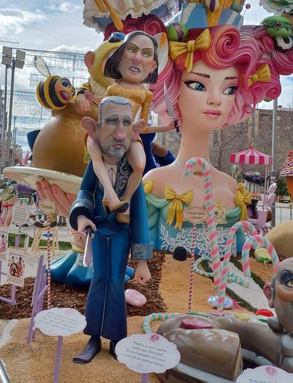 Ninots(sculpture in polispan) that are a caricature of the king Felipe with the queen letizia with her legs around his neck. Both wear knifes. At the background the falla with honey moon thematics.