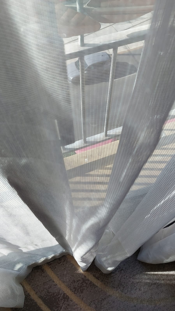 A glimpse through a hotel window to a balcony approximately 15cm deep