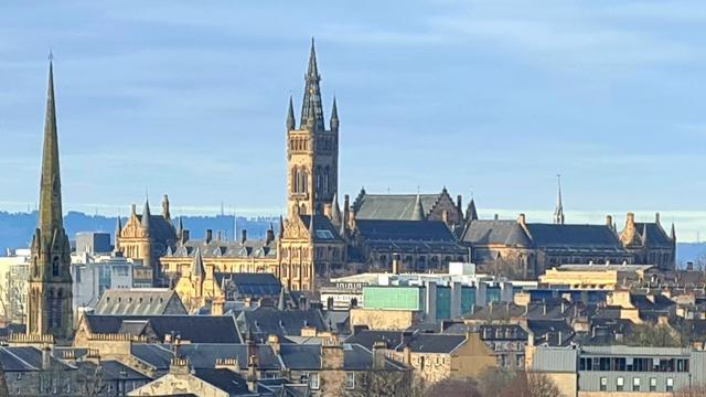 The 1870s Gothic style Glasgow University buildings rising above the buildings of the west end of the city.