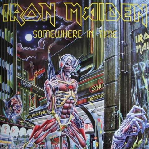 The cover art for the album Somewhere In Time by Iron Maiden.

The artwork is a painting featuring the band's mascot Eddie in some kind of cyborg form looking down to the bottom right of what looks like a robot he's shot, you can see a robotic hand reaching up. Behind him is an elaborate futuristic cityscape at night.