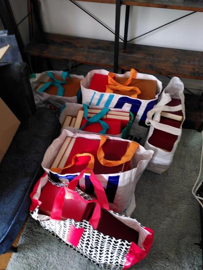 Les livres sont dans six cabas de course posés au sol.