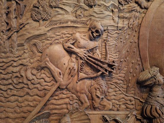 fragment drewnianej płaskorzeźby ze szkieletem łucznikiem na koniu